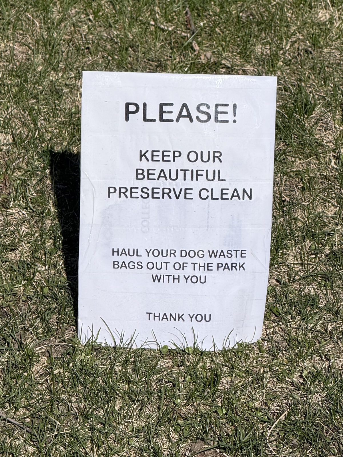Sign telling people not to leave bags of dogshit in the prairie